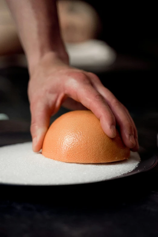 a hand reaching for an egg on a plate