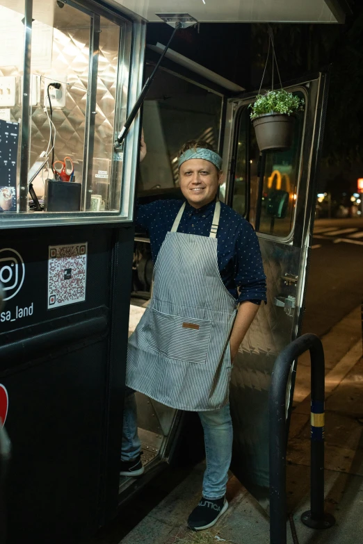 the woman is standing by a food truck