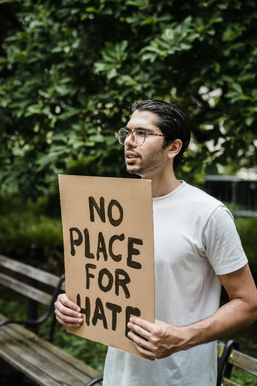 man holding a cardboard sign with no place for hate