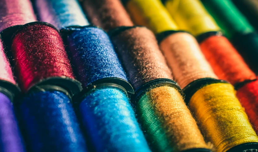 different colored spools of thread lined up in rows