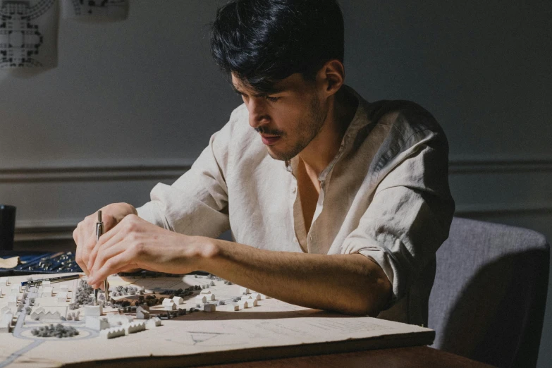 a man sitting at a table working on an architectural project