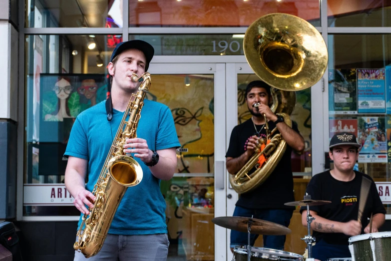 the men are playing saxophone outside together