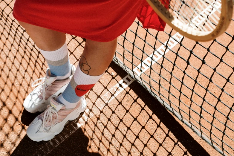 a tennis player in white socks holding a tennis racquet