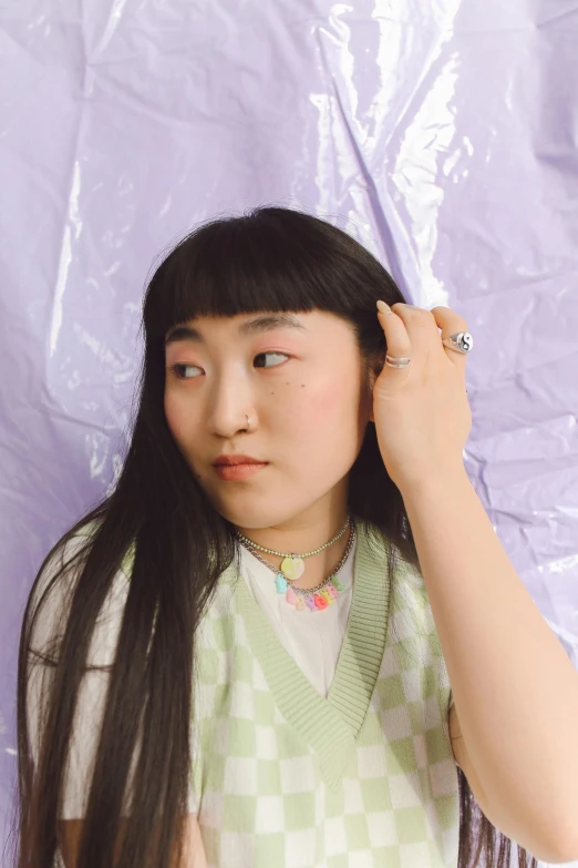 a woman holding up her long hair near her face