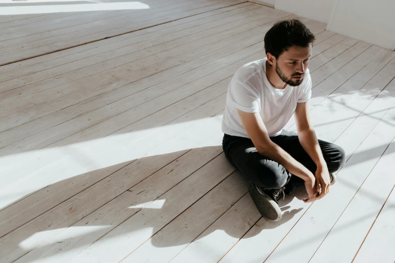 man sitting on floor with foot up on edge