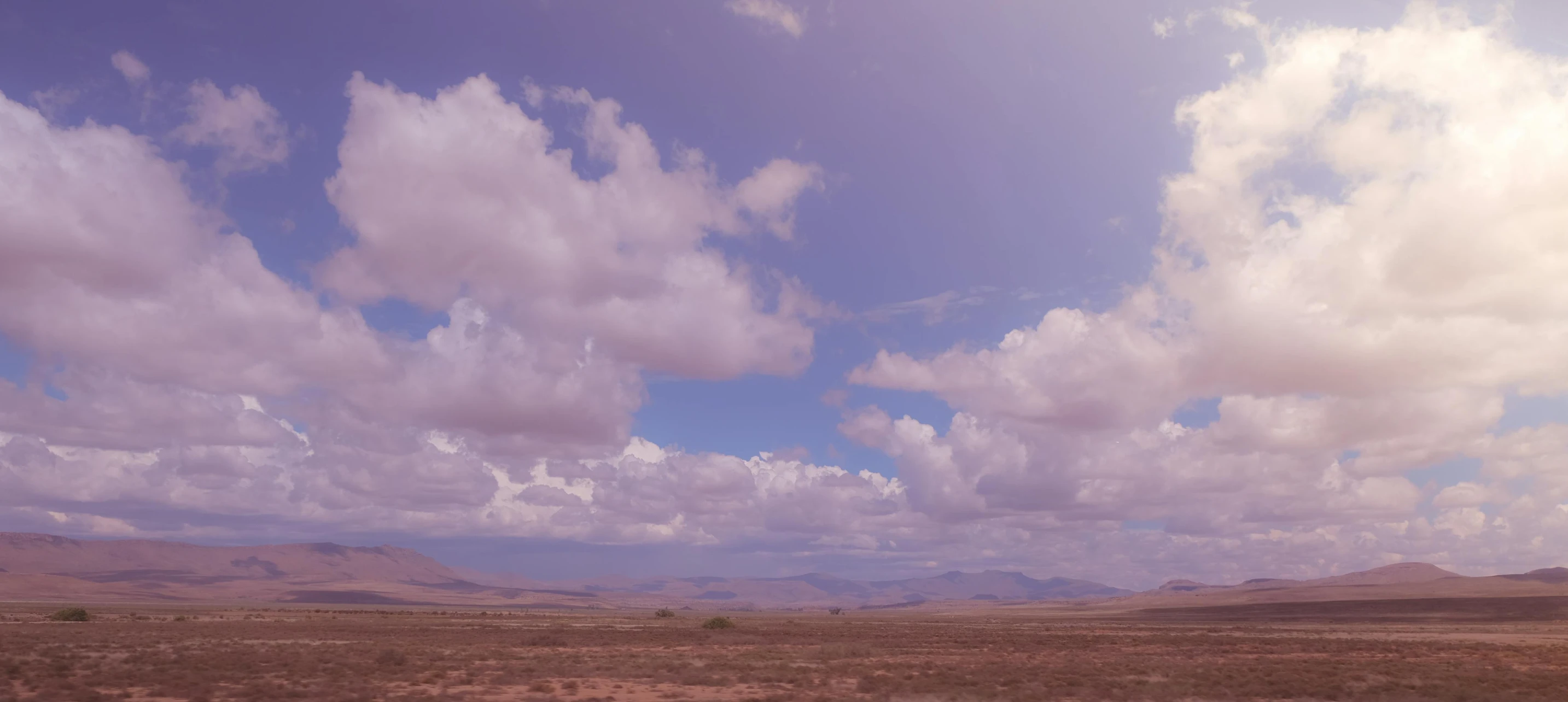 there is a field with clouds in the sky