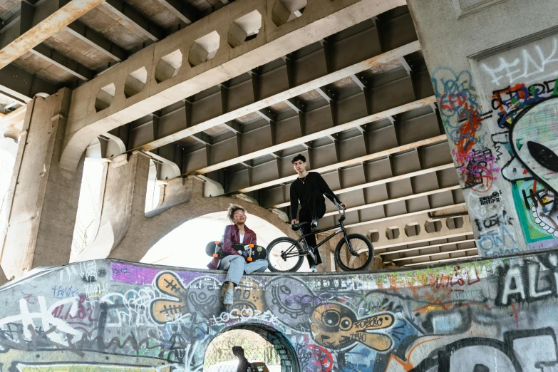 a couple of people riding bicycles on a skate ramp