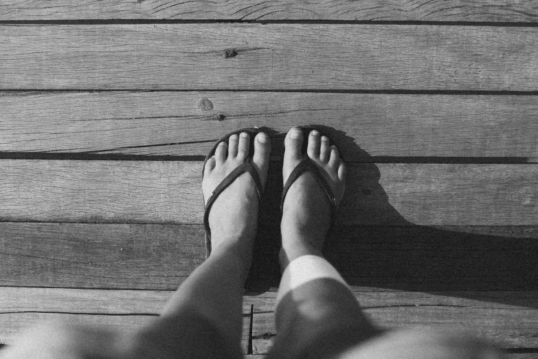 someone has their feet up on a wood platform