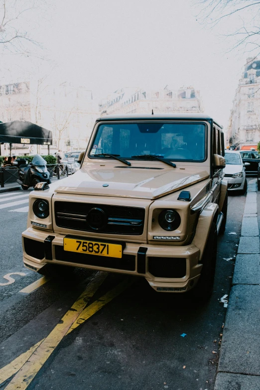 a tan mercedes benz is parked on the side of the street