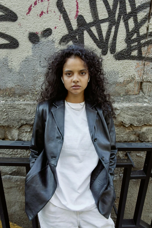 a woman standing in front of graffiti on a wall