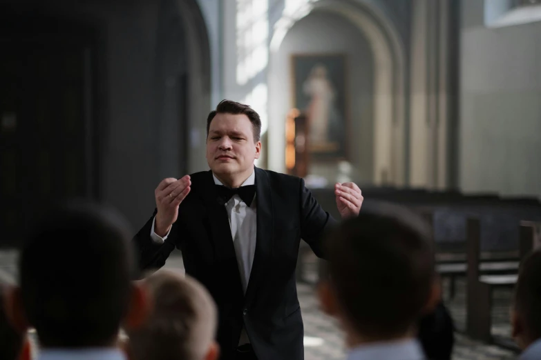 a man in a suit stands in front of some people