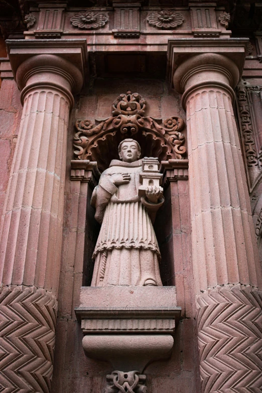 a large statue is on the side of a building
