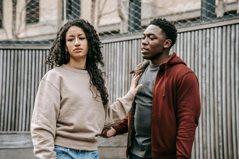 two young men are standing outside next to each other