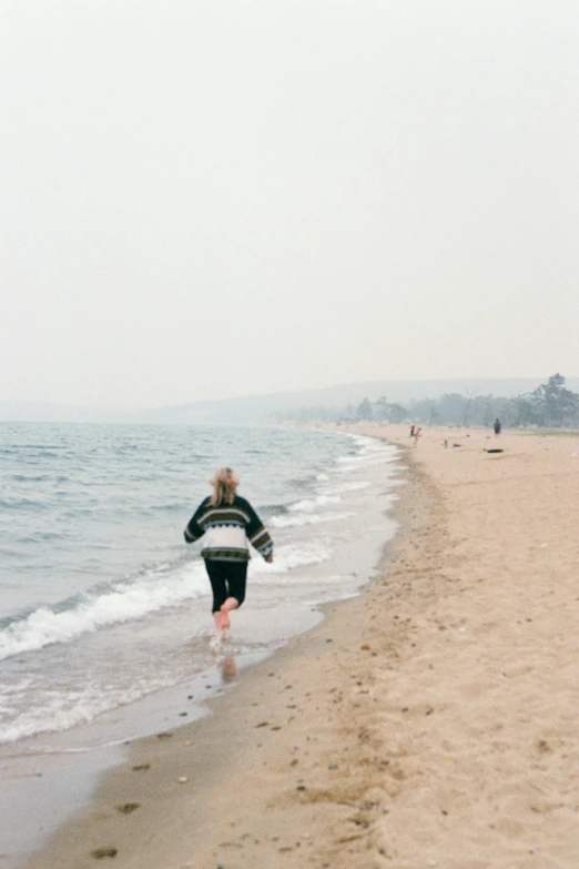 this woman is running on the beach and her long hair is flying