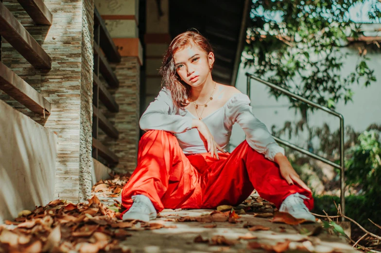 a young woman sitting on the steps, posing for the camera