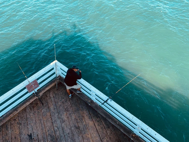 the man is looking over the water from a dock