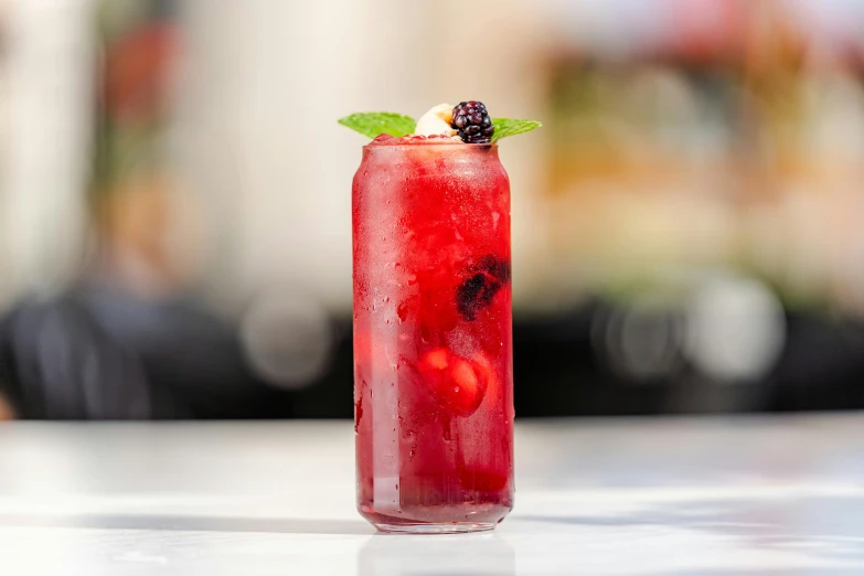 a tall glass that has a berry and mint drink