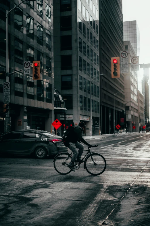 a man on a bicycle passing through an intersection