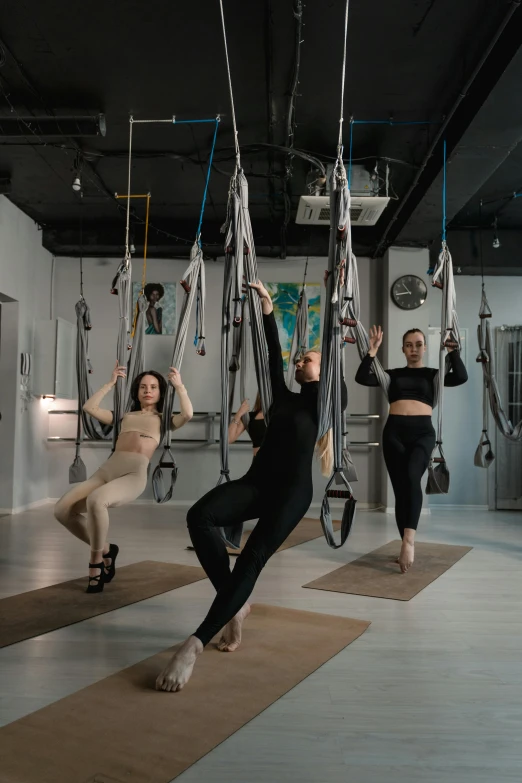 a woman hanging by one leg while others stand in the other