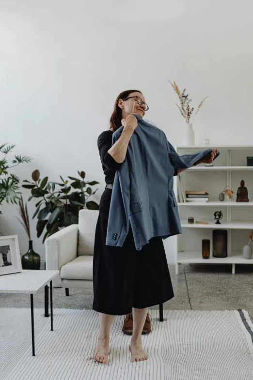 a person wearing glasses stands in the middle of a room