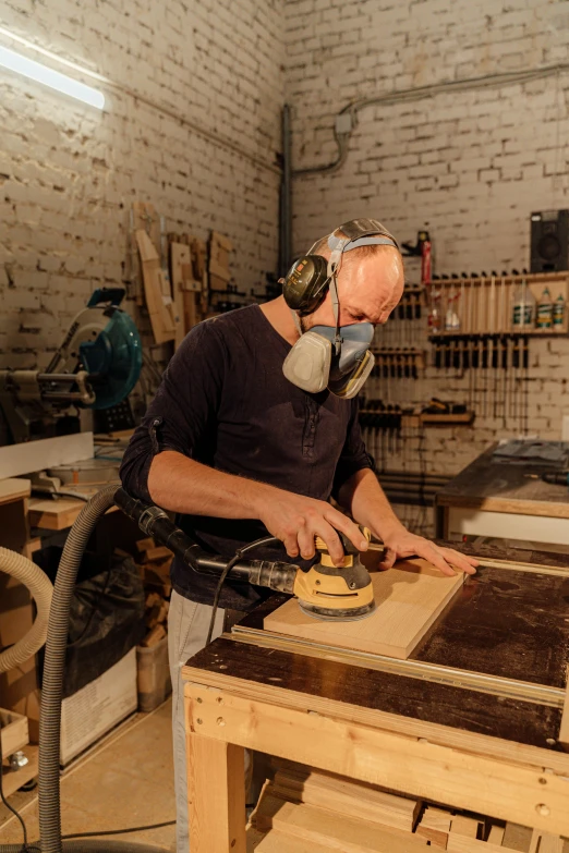 the man works on making a wooden chair