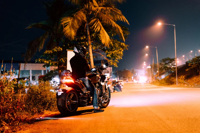 a motorcycle sits parked on the side of the road with several people behind it