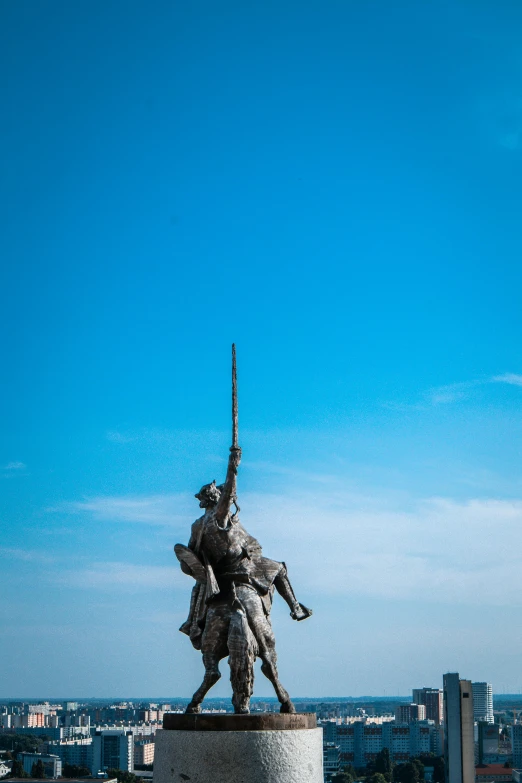 a statue sitting in the middle of a field near a building