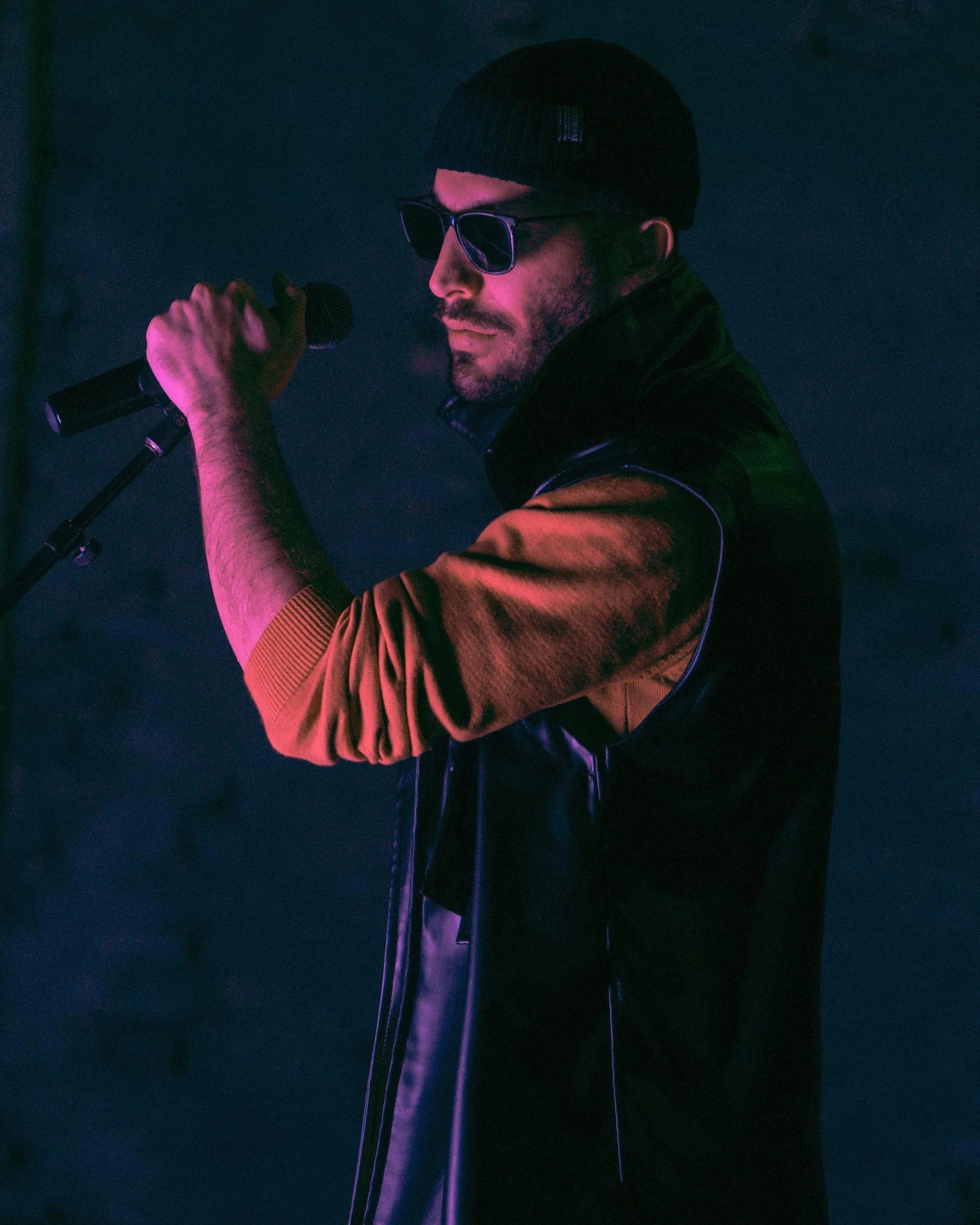 a man is singing into the microphone on stage