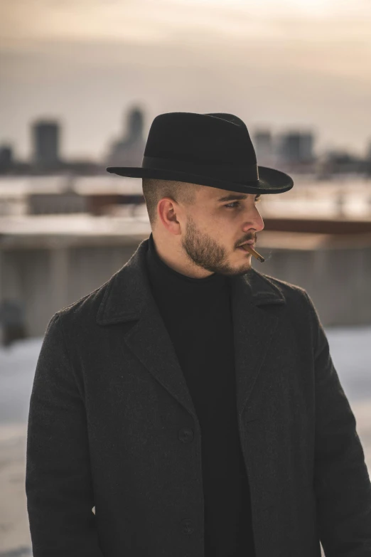 a man wearing a hat looking down to the ground