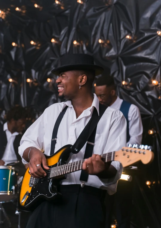 a man plays guitar with other musicians