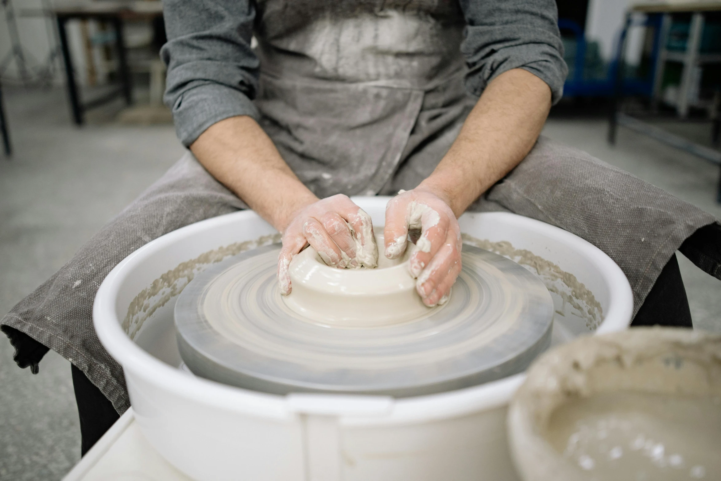 a potter working on a pottery wheel with his hands