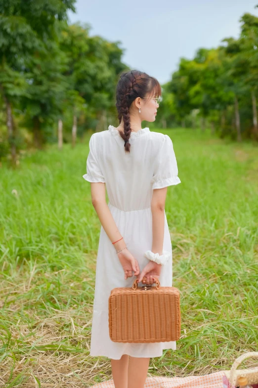 a woman in a white dress and brown basket