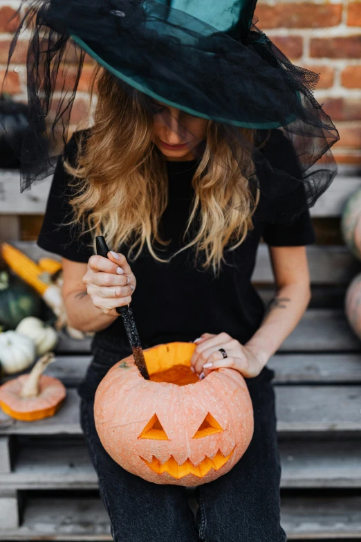 a  is sitting on the bench in her black witches hat