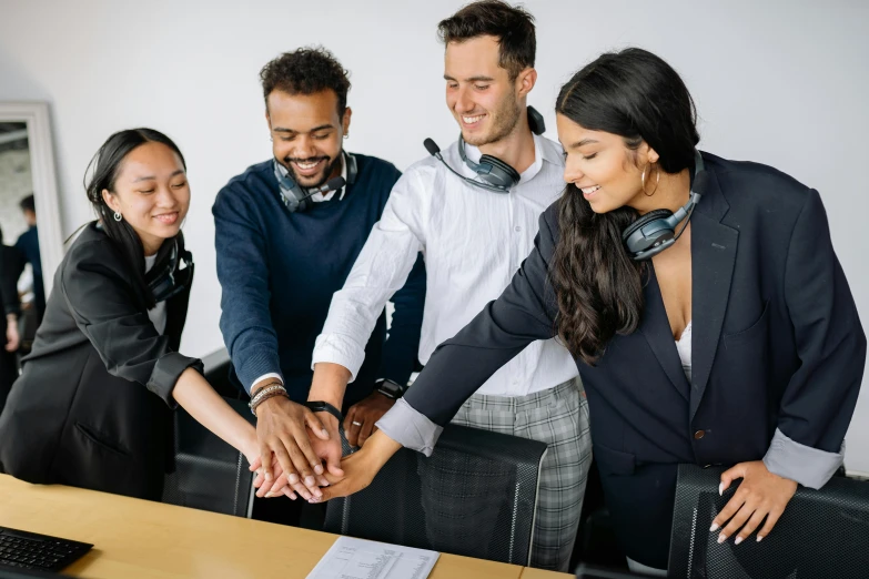 group of three people joining hands and smiling