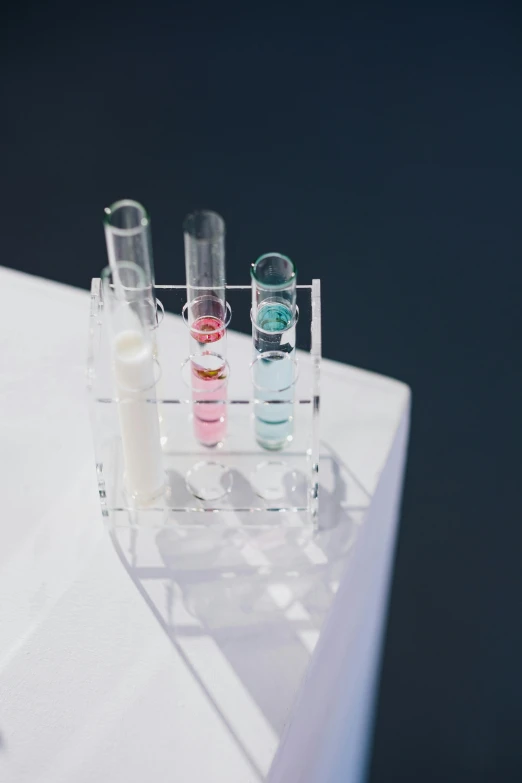 a collection of tubes of liquids in a row on a shelf