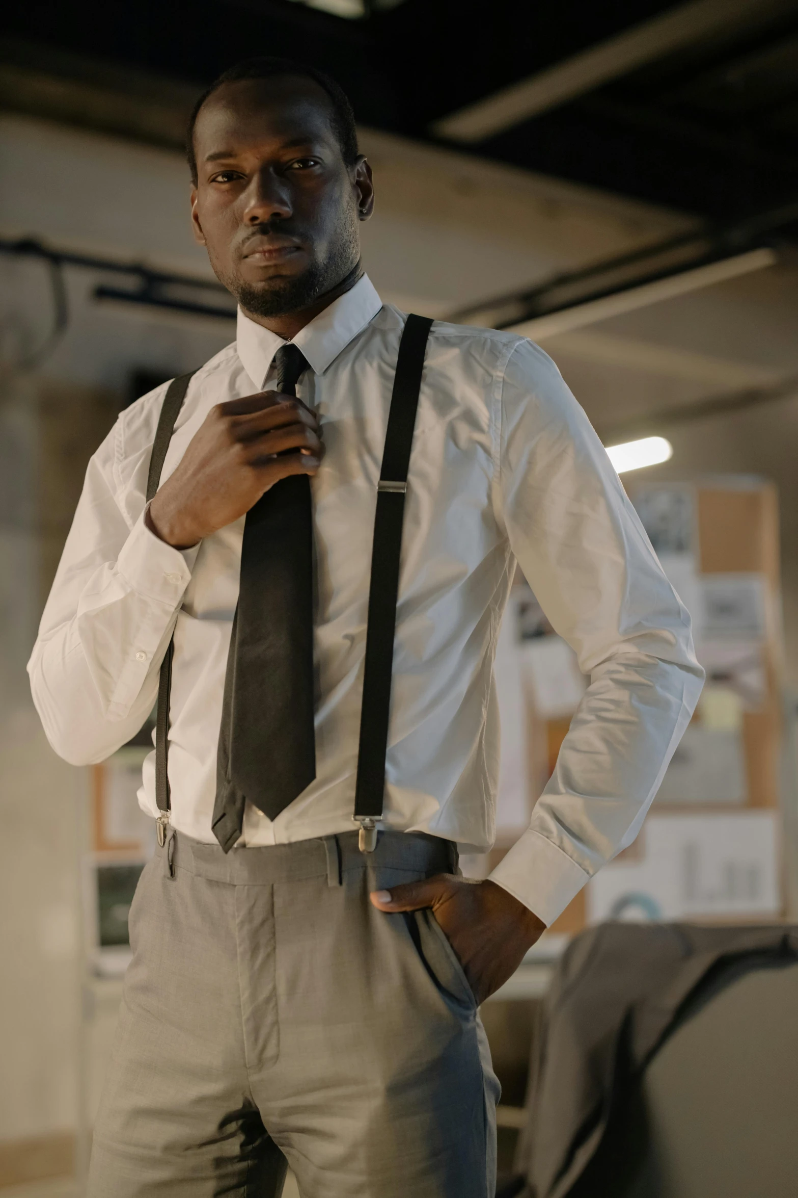 a man in an office standing with his hands on his chest