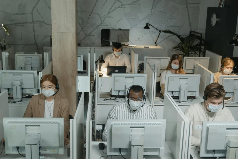 the people have white masks on their heads as they work in their office