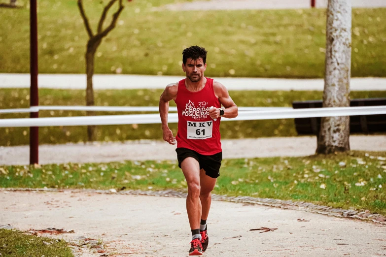 a man wearing red runs on the path