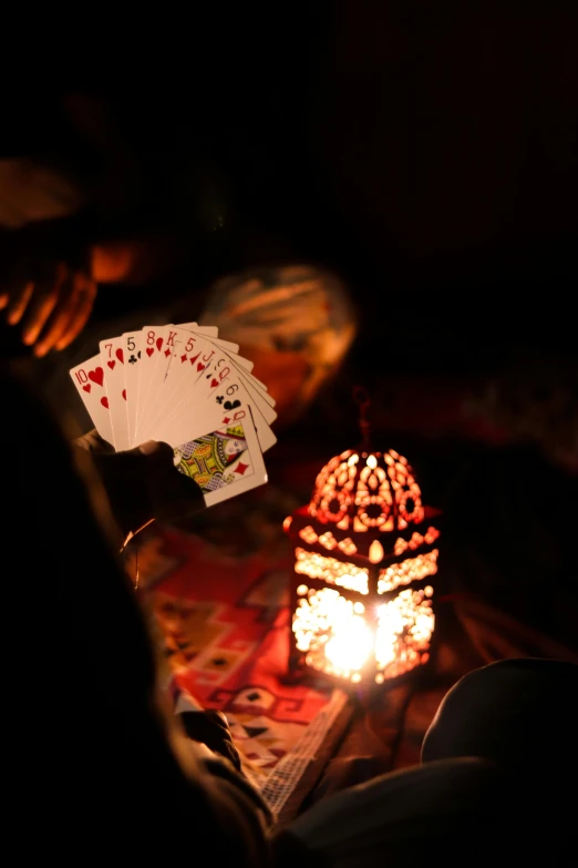 several cards, a lantern and one hand in the dark