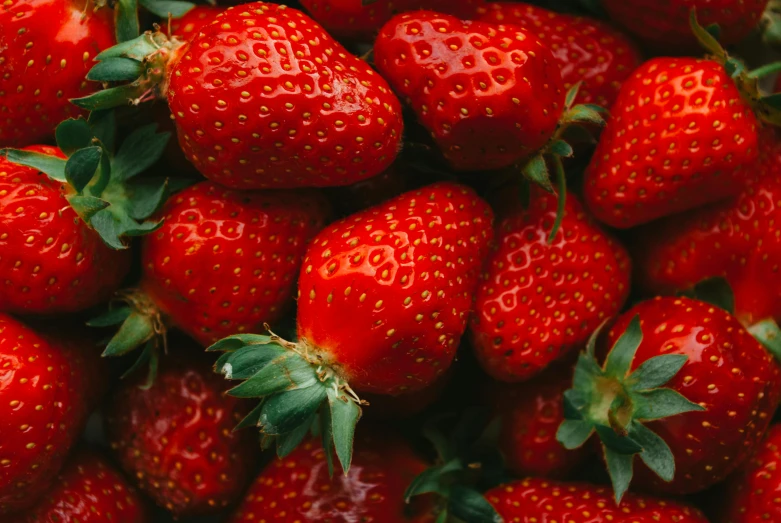 a close up of a pile of red strawberries