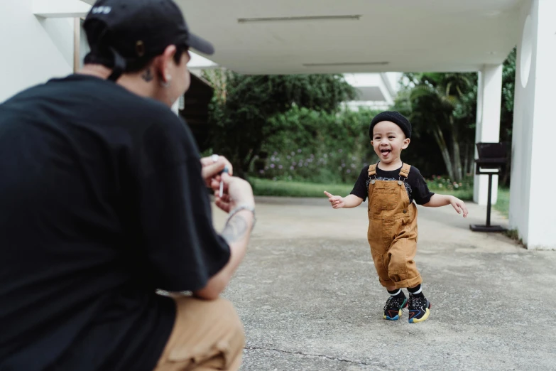 a child standing on the ground with a person talking to them