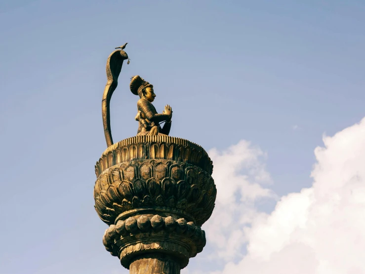 a statue of a mermaid on top of a pillar