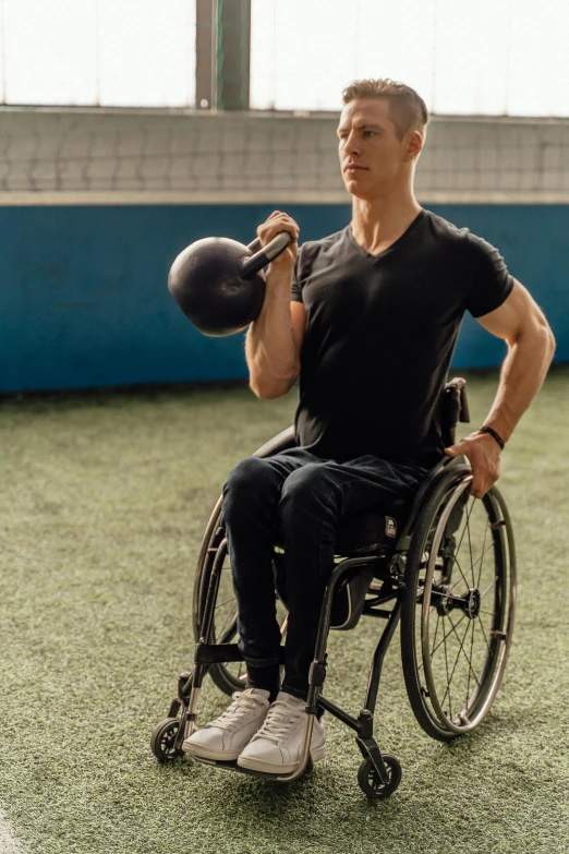 a man in a wheel chair with football helmets on