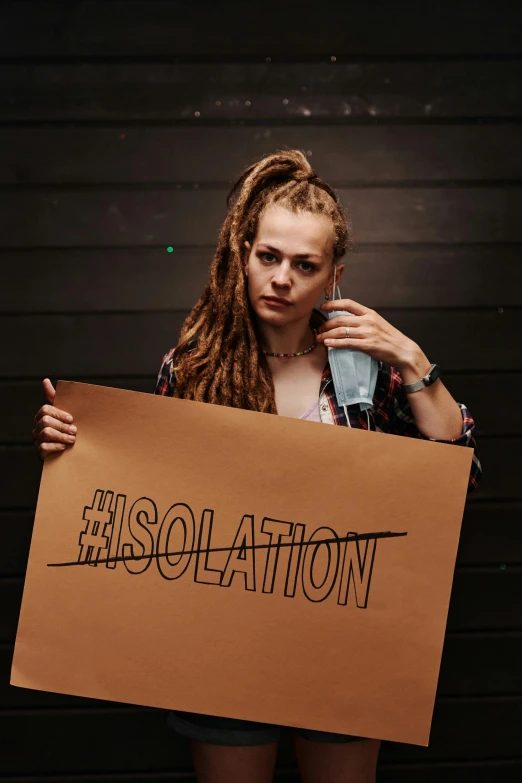 woman holding a large sign with the words isolation on it