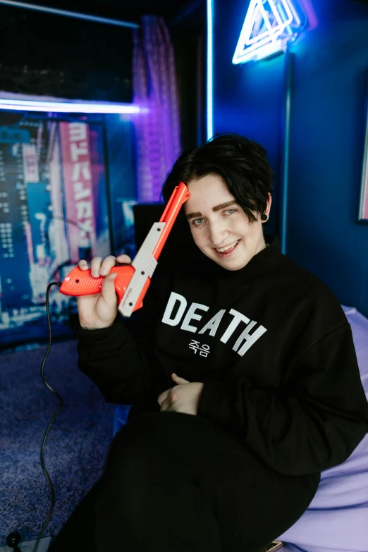 a boy in a black sweatshirt with some nintendo wii controllers