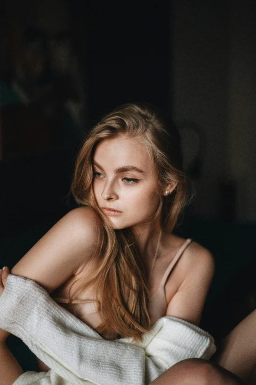 a little girl laying in a white blanket