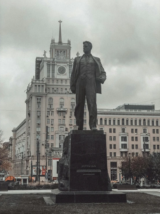 a very tall statue next to a big building