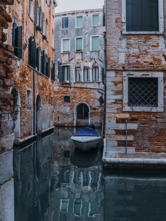 a boat floating in a canal next to tall buildings