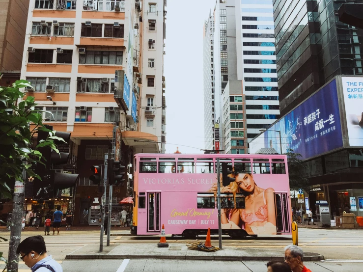 people standing and sitting in front of a pink bus