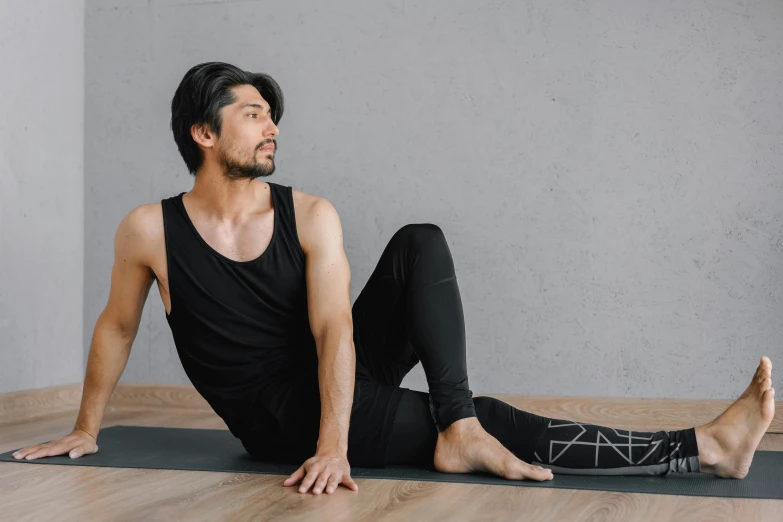 the man is practicing yoga on a mat